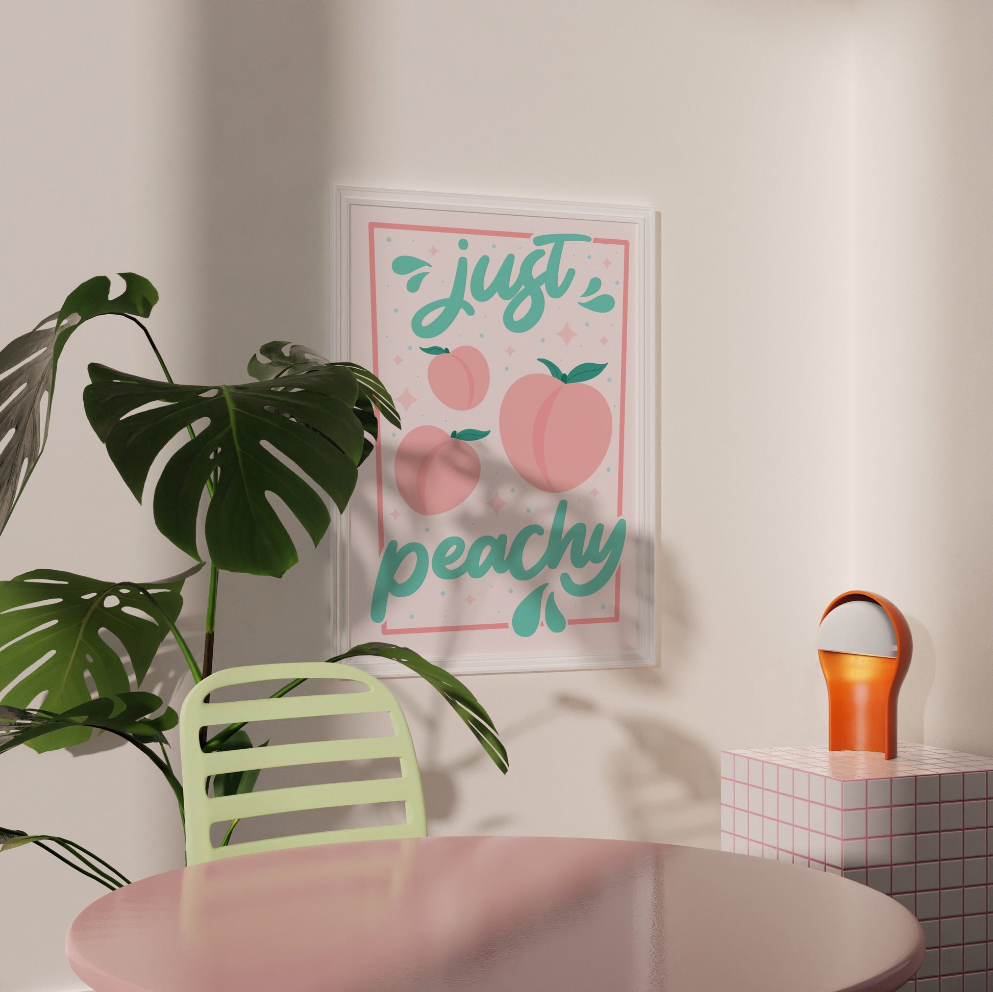 An art print with the text 'just peachy' hand-lettered in teal script, accompanied by illustrations of pink peaches and leaves, and a soft pink border.