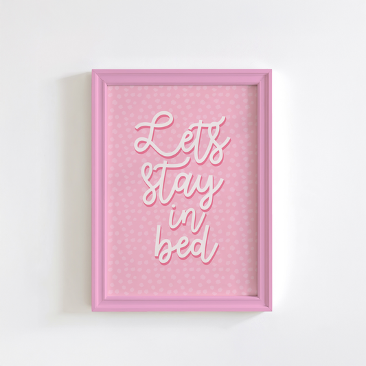 A pink polka dot print, with the words 'lets stay in bed' in a script font in the centre.