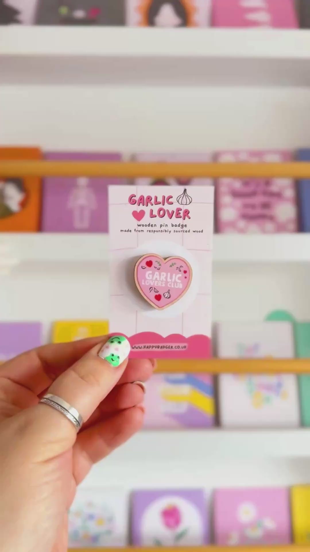 A wooden eco friendly pin badge of a pink heart with the words garlic lovers club inside of it.