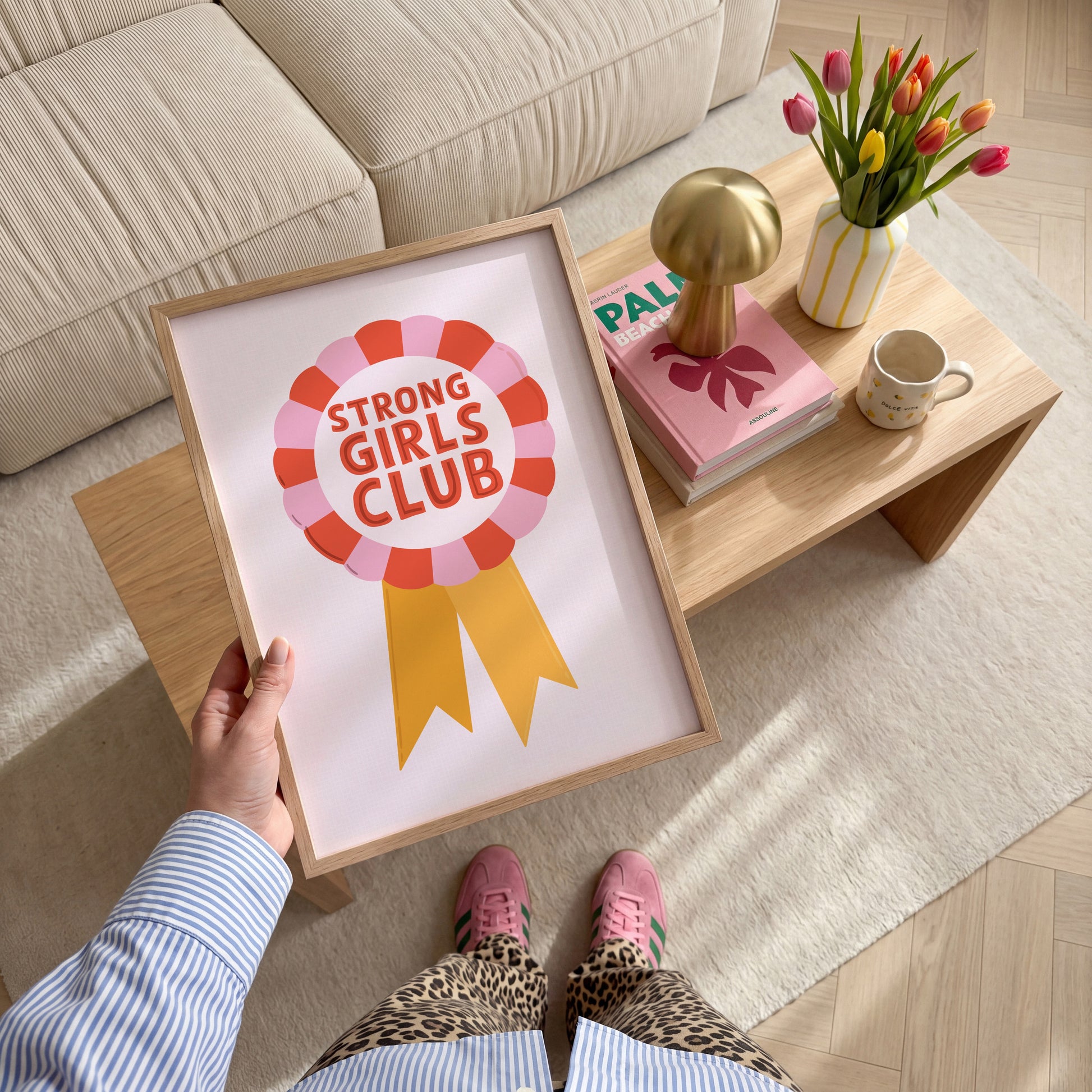 An illustration of a rosette style award, in red, pink and yellow. The award has the words 'Strong Girls Club' written in the centre of the rosette.