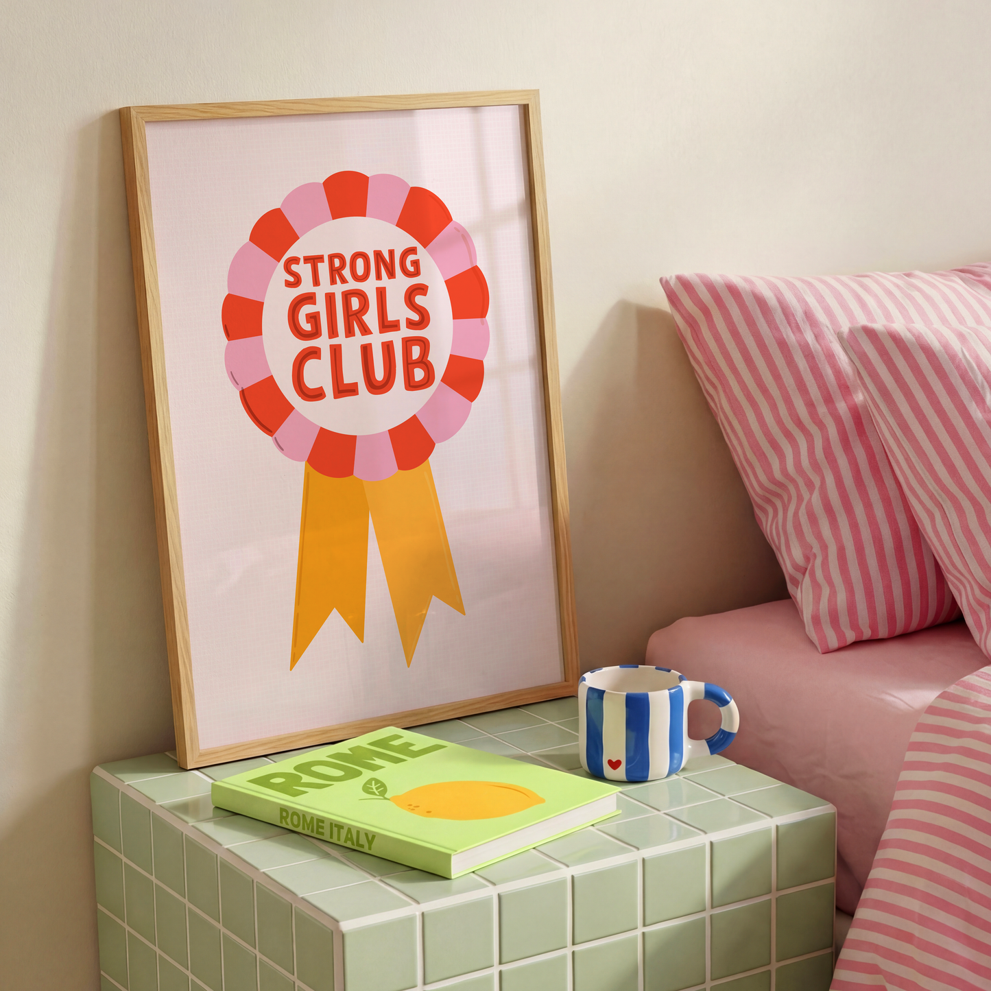 An illustration of a rosette style award, in red, pink and yellow. The award has the words 'Strong Girls Club' written in the centre of the rosette.