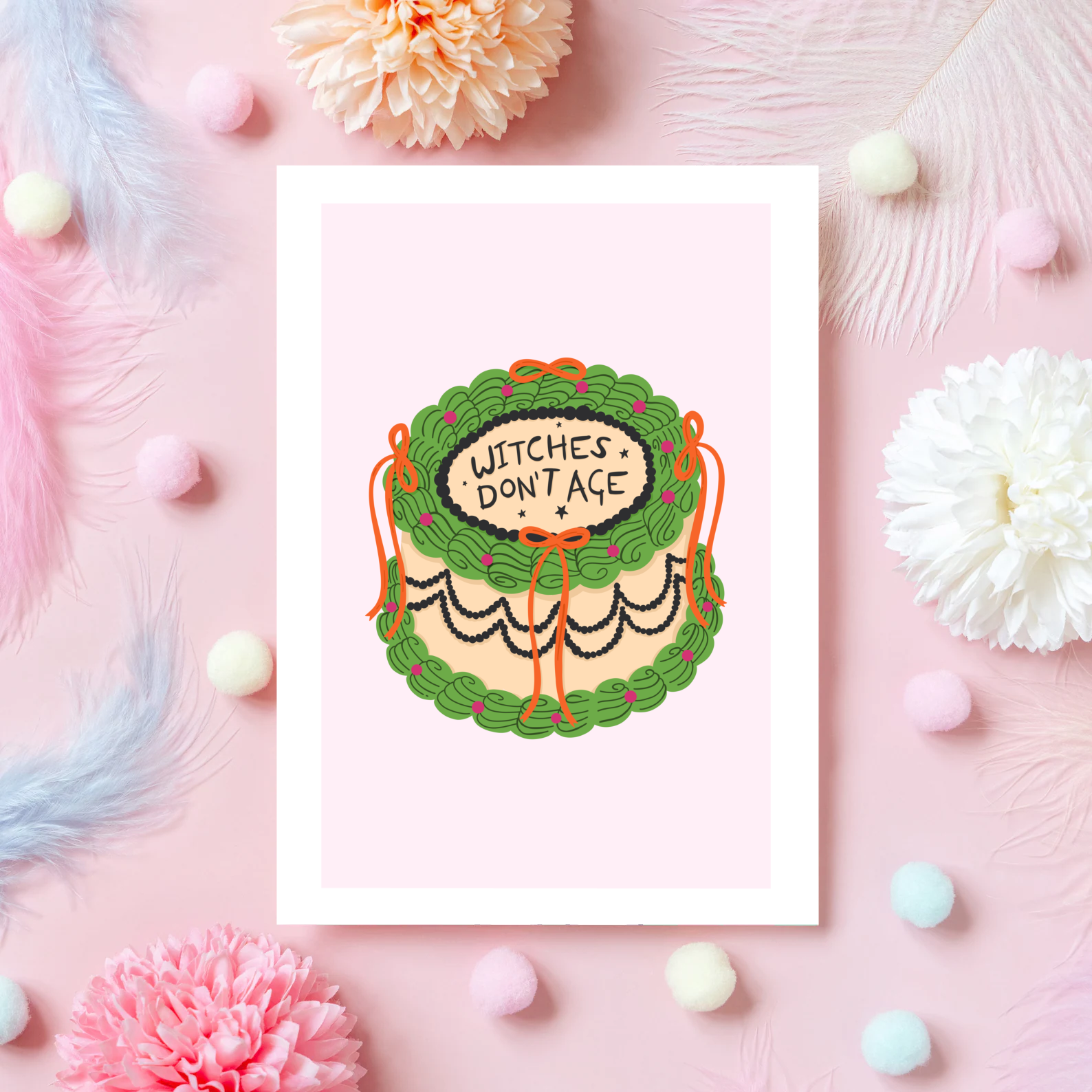 a card with an illustration of a birthday cake, in green and orange, with the words 'witches don't age' on top.