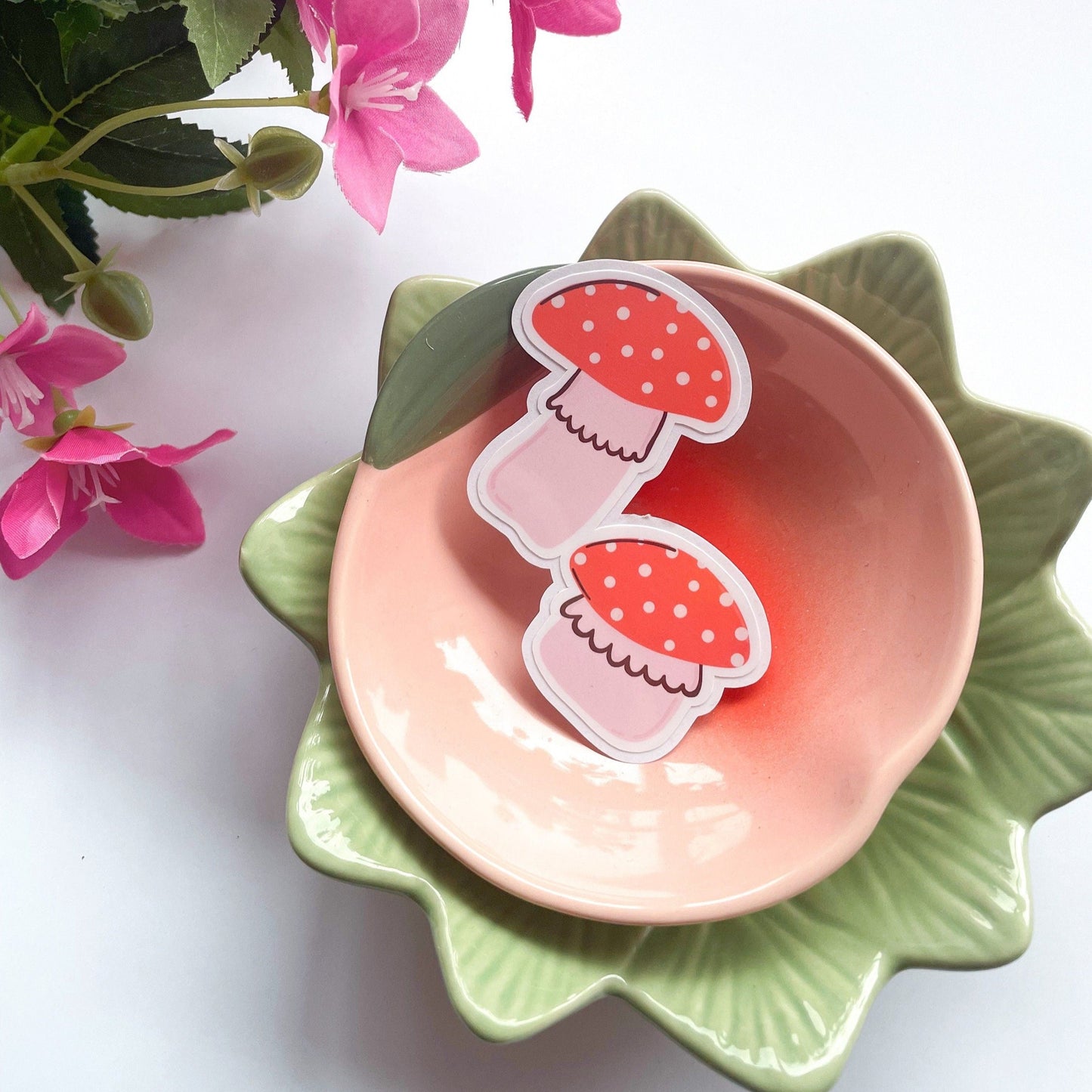 A holographic sticker, of two cute red and pink mushrooms. The sticker has an easy peel lip.