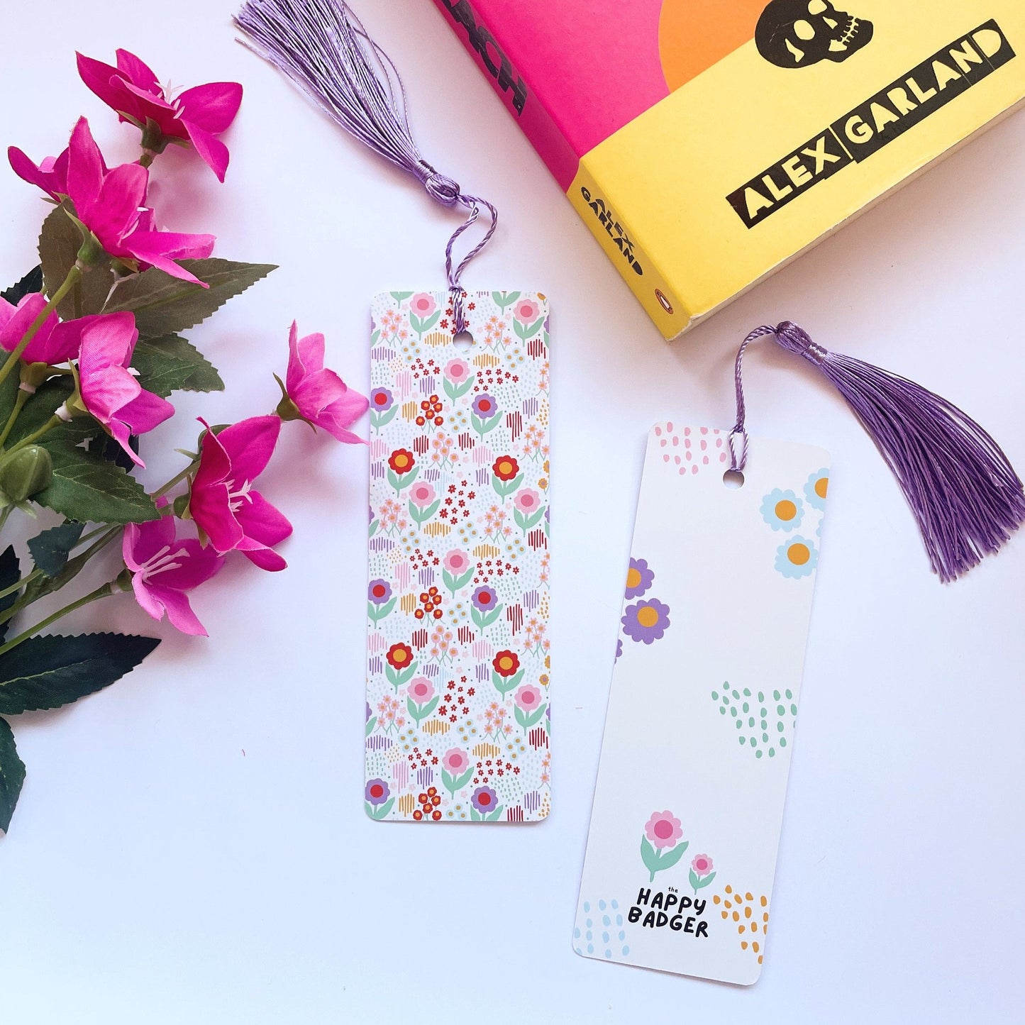 A picture of a brightly coloured floral patterned bookmark, with a coordinating purple tassel.