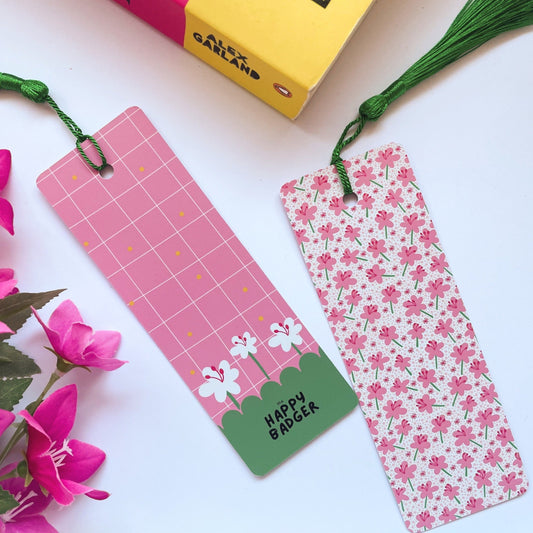 A picture of a brightly coloured pink floral patterned bookmark, with a coordinating green tassel.